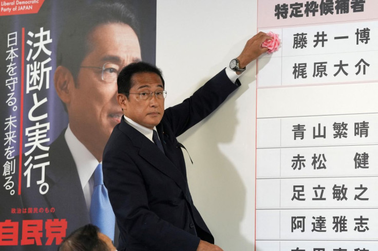 Fumio Kishida, Japan's Prime Minister and president of the Liberal Democratic Party (LDP), places a red paper rose on an LDP candidate's name, to indicate a victory in the upper house election, at the party's headquarters in Tokyo, Japan, July 10, 2022. T