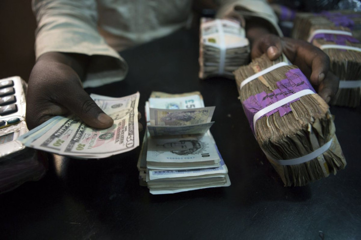 A trader changes dollars with naira at a currency exchange store in Lagos February 12, 2015.