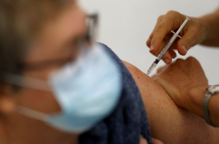 A medical worker administers a dose of the "Cominarty" Pfizer-BioNTech coronavirus disease (COVID-19) vaccine to a patient at a vaccination center in Ancenis-Saint-Gereon, France, November 17, 2021. 