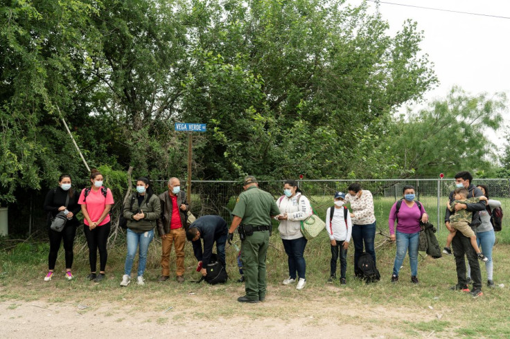 Asylum-seeking migrants' families from Venezuela wait to be transported by the U.S. Border Patrols after crossing the Rio Grande river into the United States from Mexico in Del Rio, Texas, U.S., May 27, 2021. 