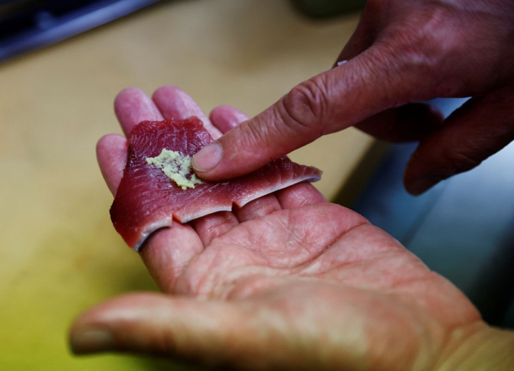 Noriaki Ito, 57, head chef of 106 year-old restaurant Tsukasa, puts wasabi on a piece of raw katsuo (skipjack tuna), in Kochi, Kochi Prefecture, Japan, May 13, 2022.