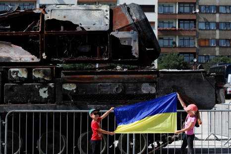 Children hold up a Ukrainian flag near Russian military equipment destroyed by the Armed Forces of Ukraine displayed, as Russia's attack on Ukraine continues, in Prague, Czech Republic, July 11, 2022.  