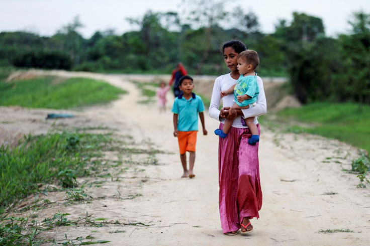 Venezuelan refugees walk to a school, where a temporary shelter is installed, to receive medical assistance and humanitarian aid from the Colombian Red Cross, in Arauquita, Colombia March 28, 2021.