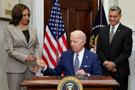 U.S. President Joe Biden hands the pen to Vice President Kamala Harris as Health and Human Services Secretary Xavier Becerra stands near after signing an executive order to help safeguard women's access to abortion and contraception after the Supreme Cour