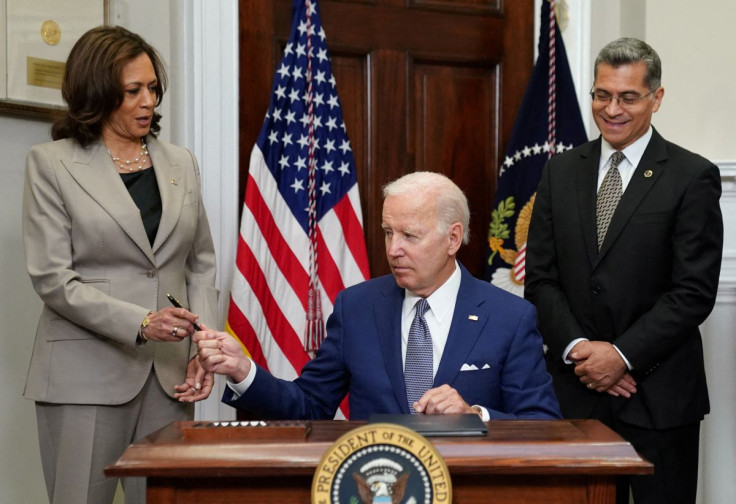 U.S. President Joe Biden hands the pen to Vice President Kamala Harris as Health and Human Services Secretary Xavier Becerra stands near after signing an executive order to help safeguard women's access to abortion and contraception after the Supreme Cour