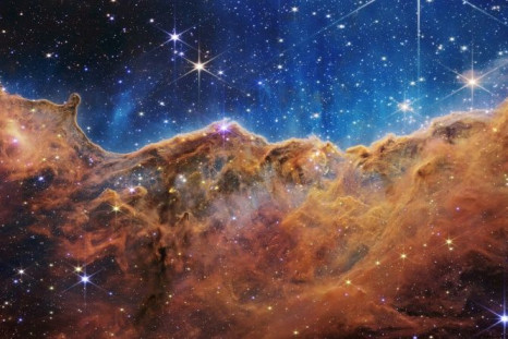 This image from the James Webb Space Telescope shows âmountainsâ and âvalleysâ speckled with glittering stars which is actually the edge of a nearby, young, star-forming region called NGC 3324 in the Carina Nebula