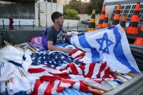 A worker prepares Israeli and US national flags in Jerusalem ahead of US President Joe Biden's visit to Israel