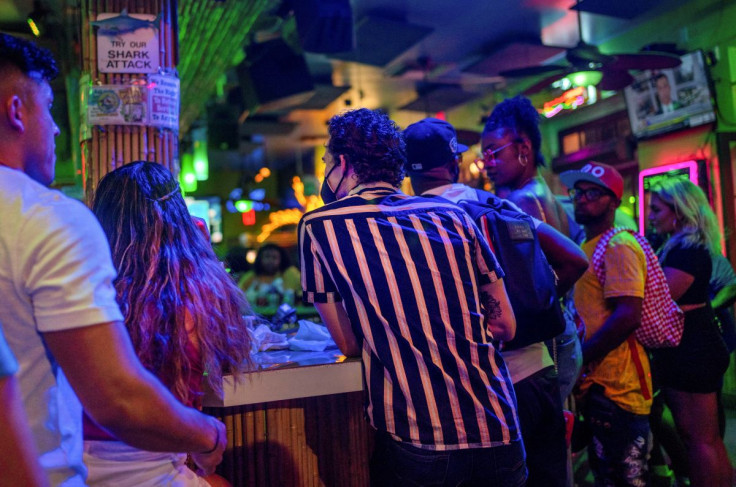 Masked and unmasked revelers wait for service at a bar on Bourbon Street in New Orleans, Louisiana, U.S., July 23, 2021. 