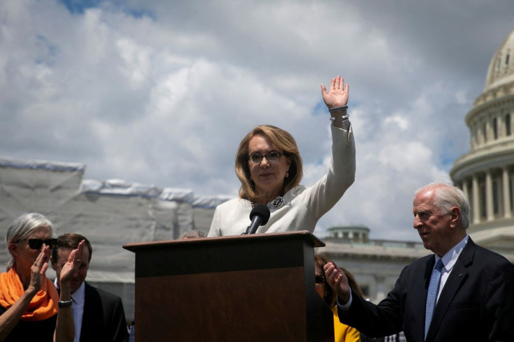 Shooting survivor and former Representative Gabby Giffords (D-AZ) waves as she speaks, as U.S. Representative Mike Thompson (D-CA) listens, during a news conference to schedule a Senate vote on the Background Checks Expansion Act, on the East Front of the