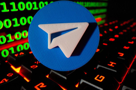 A 3D printed Telegram logo is pictured on a keyboard in front of binary code in this illustration taken September 24, 2021. 