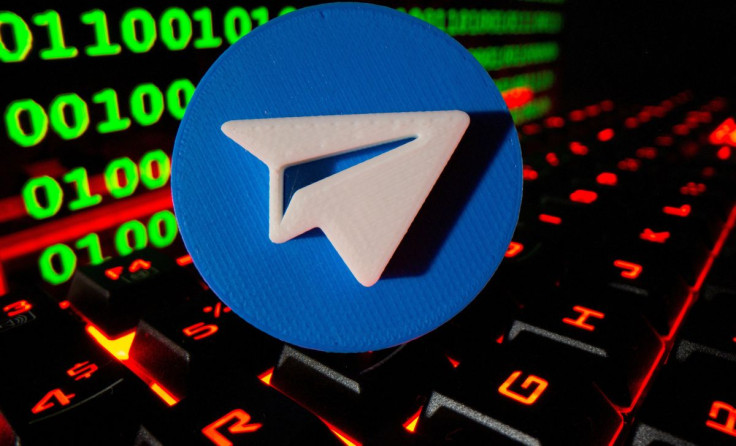 A 3D printed Telegram logo is pictured on a keyboard in front of binary code in this illustration taken September 24, 2021. 