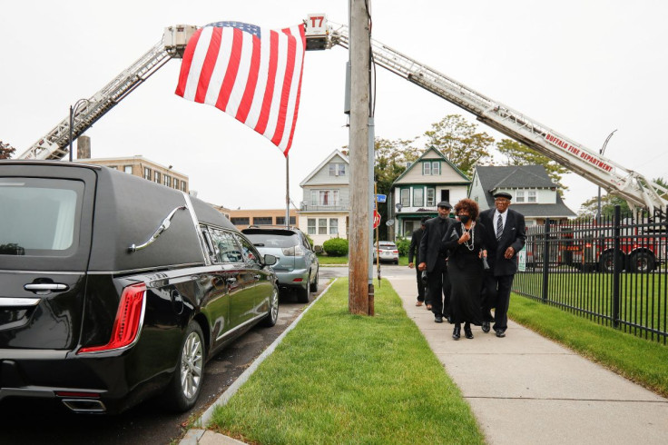 People walk past a hearse outside funeral for Buffalo shooting victim Ruth Whitfield who was shot and killed in the attack by an avowed white supremacist at Tops supermarket, in Buffalo, New York, U.S. May 28, 2022.