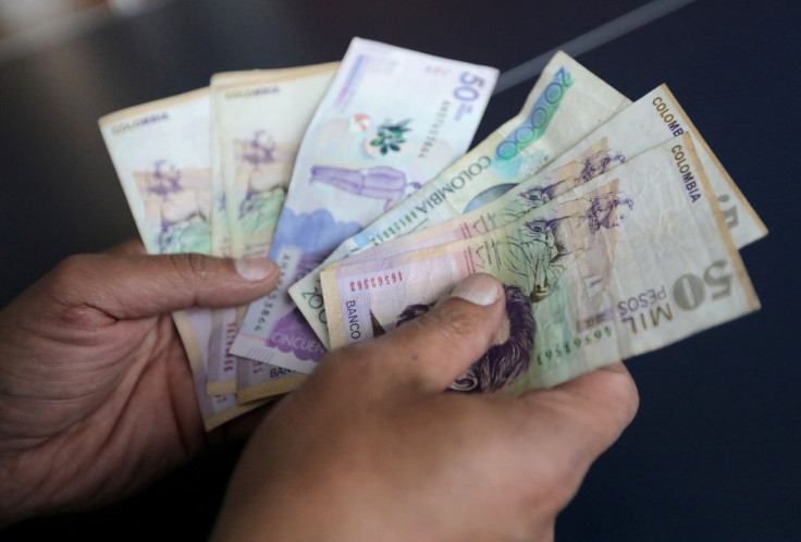 A employee counts Colombian pesos at a store in Bogota, Colombia December 28, 2018.