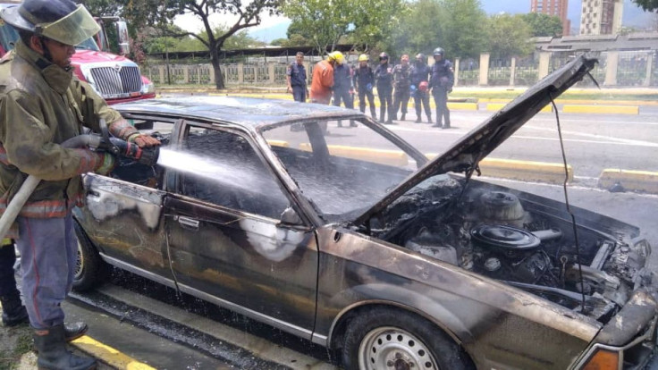 A fire fighter extinguishes a fire that broke out in a car, in Maracay, Venezuela April 24, 2022. Stringer/Handout via REUTERS