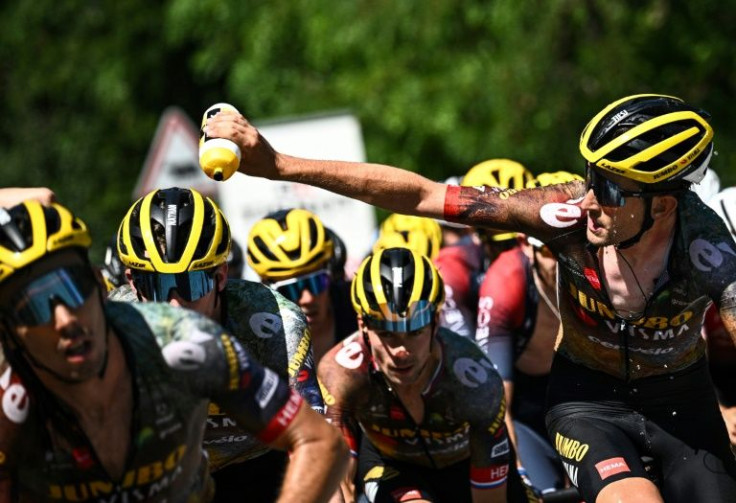 Hot work: Jumbo-Visma team's Belgian rider Tiesj Benoot (right) douses his teammates with water to cool down in the Alps