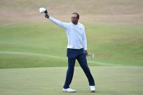 Tiger Woods gestures to the crowd on the 18th green at the end of his second round