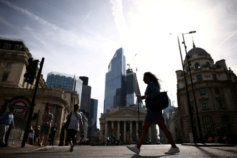 People walk through the City of London financial district during warm weather in London, Britain, June 17, 2022. 