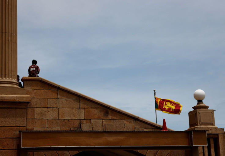 A demonstrator rests at the Presidential Secretariat after Parliament Speaker Mahinda Yapa Abeywardena officially announced the resignation of president Gotabaya Rajapakse who fled to Singapore following Sri Lanka's economic meltdown and mass protests, am