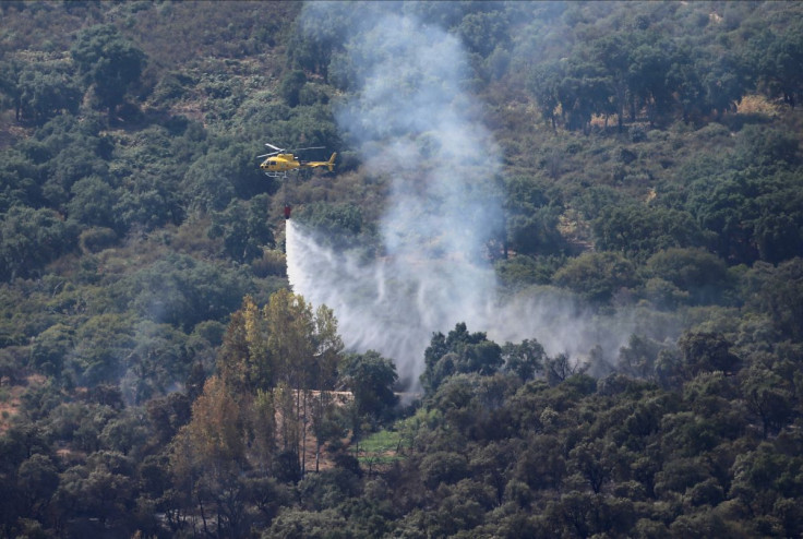 A helicopter works on containing a wildfire during the second heatwave of the year in the vicinity of Casas de Miravete, Spain, July 16, 2022. 