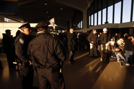 Police officers stand in front of a line of passengers in Terminal A at Newark Liberty Airport shortly after reopening the terminal to passengers in Newark.