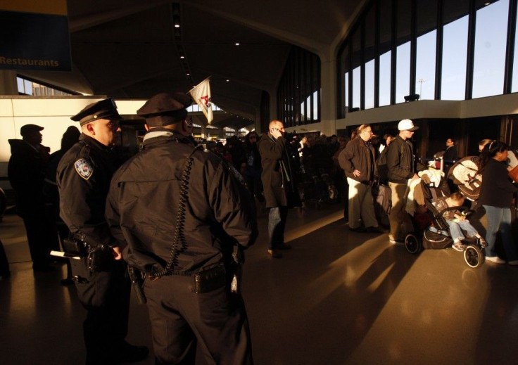 Police officers stand in front of a line of passengers in Terminal A at Newark Liberty Airport shortly after reopening the terminal to passengers in Newark.