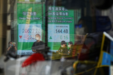 A vehicle drives past a screen displaying the Hang Seng stock index at Central district, in Hong Kong, China July 19, 2022. 