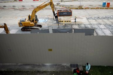 People sit outside a construction site in Singapore February 16, 2021. 