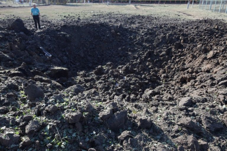 A man stands in front of a crater following a Russian airstrike in the Odessa region