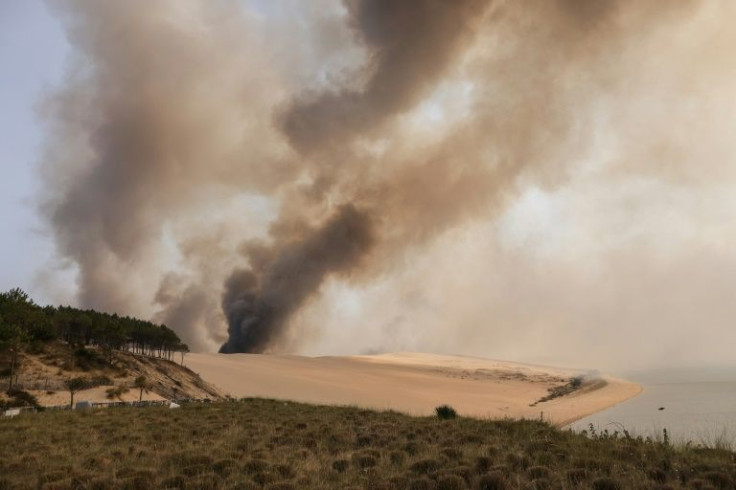 This photograph taken on July 18, 2022 shows the smoke rising from the forest fire in La Teste-de-Buch, seen from Pyla sur Mer, in front of the Pilat dune.  In scorching heat, with more than 40Â°C, some 8,000 people had to leave - in a "preventive manner"
