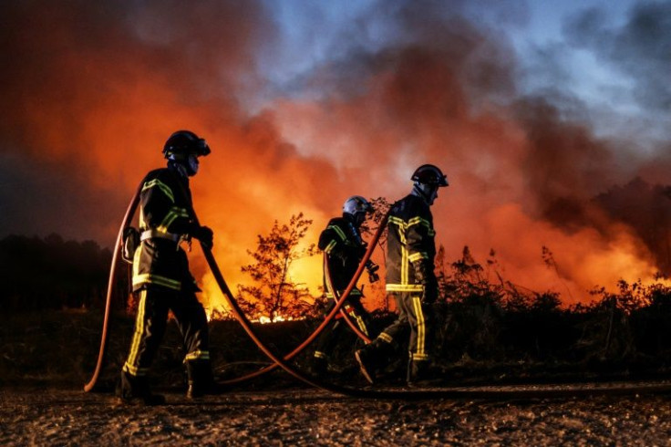 Firefighters try to control a separate fire further inland from the Dune de Pilat.