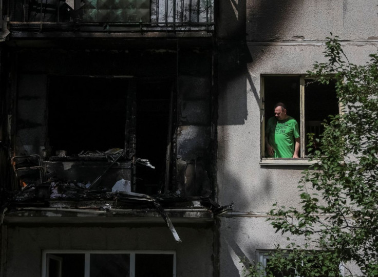 A local resident looks out through a broken window in his flat in a residential building damaged by a Russian military strike, amid Russia's invasion on Ukraine, in Kramatorsk, in Donetsk region, Ukraine July 19, 2022. 