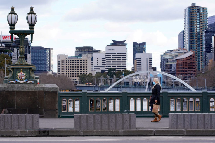 A lone woman, wearing a protective face mask, walks across a city centre bridge as the state of Victoria looks to curb the spread of a COVID-19 outbreak in Melbourne, Australia, July 16, 2021.