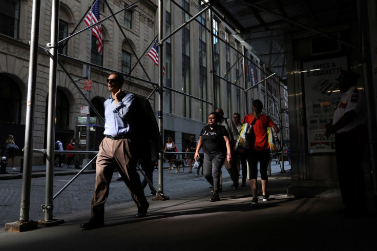 People walk on Wall St. during the morning commute, as the city deals with record temperatures and the excessive heat, in New York City, U.S., July 20, 2022.  