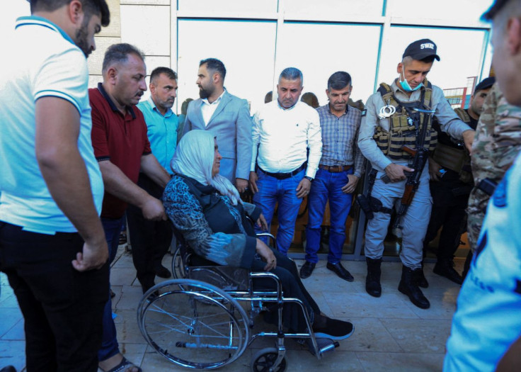 A man pushes a wheelchair carrying a woman wounded by a Turkish attack, next to a hospital in Zakho, Iraq, July 20, 2022. 