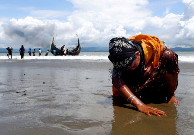 An exhausted Rohingya refugee woman touches the shore after crossing the Bangladesh-Myanmar border by boat through the Bay of Bengal in Shah Porir Dwip, Bangladesh, September 11, 2017. Picture taken September 11, 2017. 