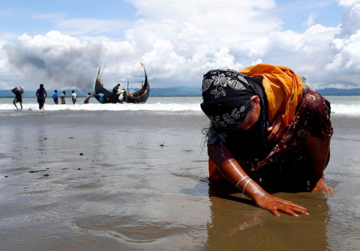 An exhausted Rohingya refugee woman touches the shore after crossing the Bangladesh-Myanmar border by boat through the Bay of Bengal in Shah Porir Dwip, Bangladesh, September 11, 2017. Picture taken September 11, 2017.