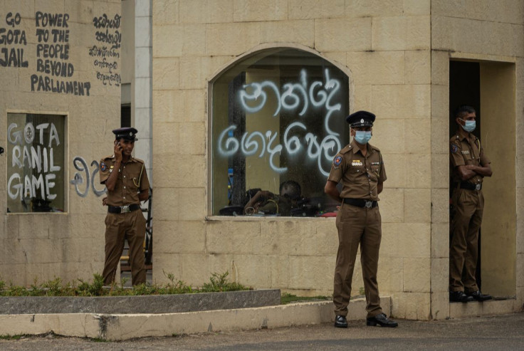 Policemen stand guard next to a graffitied wall following protests near the President's House, amid the country's economic crisis, in Colombo, Sri Lanka July 21, 2022.