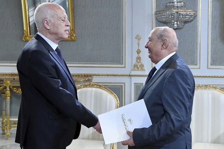 A handout picture provided by the Tunisian presidency on June 20 shows Sadok Belaid, head of Tunisiaâs constitution committee, submitting a draft of the new constitution to President Kais Saied