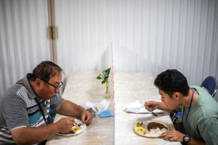 Koichi Miyatsu (R) and his adoptive father Yoshimitsu eat curry together after their monthly charity event at a church in Kumamoto