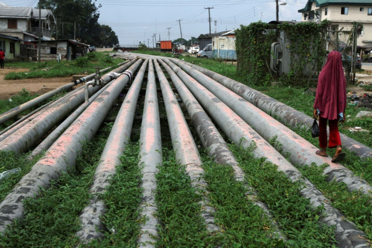 A girl walks on a gas pipeline running through Okrika community near Nigeria's oil hub city of Port Harcourt December 4, 2012.