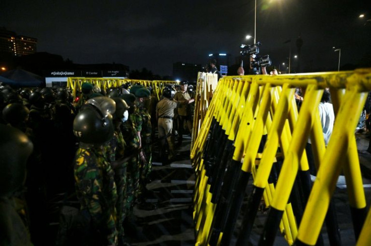 Members of Sri Lankan security forces gather at the site of protest camp in front of the Presidential Secretariat in Colombo
