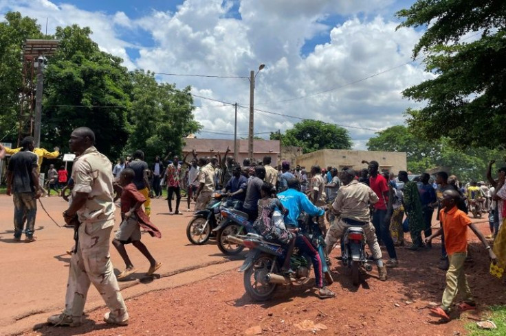 A crowd gathered after the attack, beating up a man (not seen) who was suspected of taking part in the raid