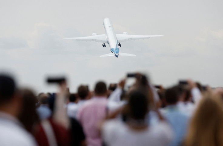 Attendees watch a Boeing 777X aircraft during a display at the Farnborough International Airshow, in Farnborough, Britain, July 20, 2022.  