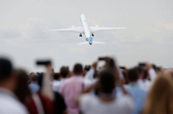 Attendees watch a Boeing 777X aircraft during a display at the Farnborough International Airshow, in Farnborough, Britain, July 20, 2022.