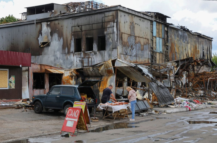 A street vendor sells meat products in front of a destroyed market near a railway station in the course of Ukraine-Russia conflict in Donetsk, Ukraine July 22, 2022.