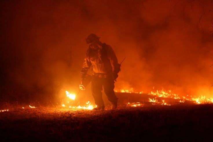 A firefighter lights a backfire while battling the Oak Fire on July 23, 2022 in California