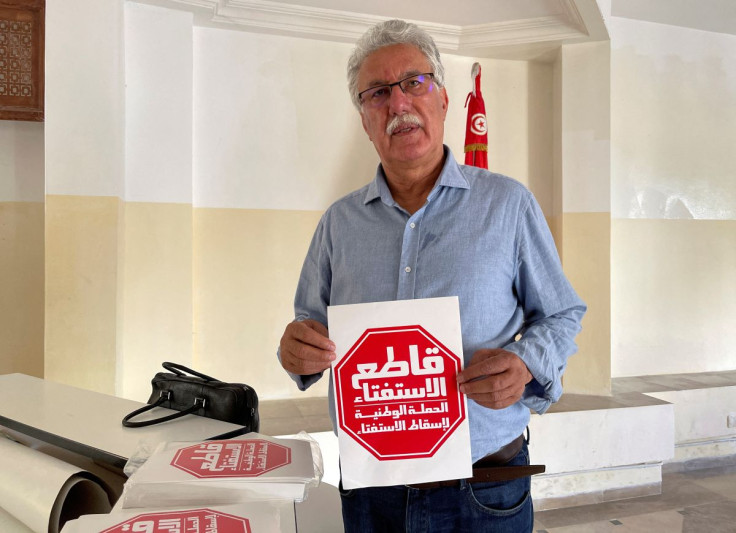 Hamma al-Hammami, a leftist activist and former political prisoner, displays a flyer that reads 'Boycott the referendum' during an interview with Reuters in Tunis, Tunisia July 22, 2022.