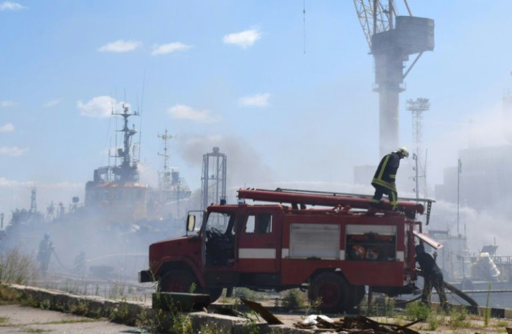 A handout image made available by the Odessa City Council Telegram channel on July 24, 2022, shows Ukrainian firefighters battling a fire on a boat burning in the port of Odessa after missiles hit the port on July 23, 2022.Russia on July 24, 2022, sai