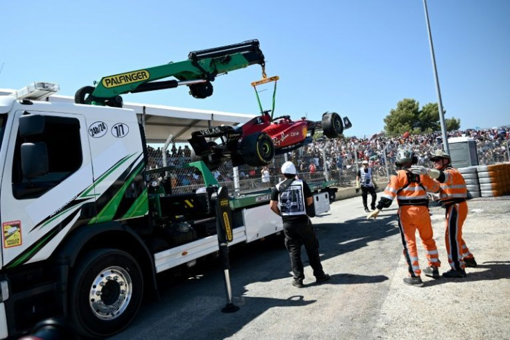 Charles Leclerc's car is taken away from the track after he crashed out while in the lead
