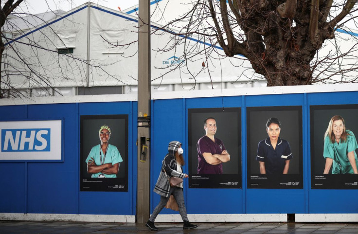 A person walks past images of National Health Service (NHS) workers displayed on hoardings outside a temporary field hospital at St George's Hospital, amid the coronavirus disease (COVID-19) outbreak in London, Britain, January 8, 2022.